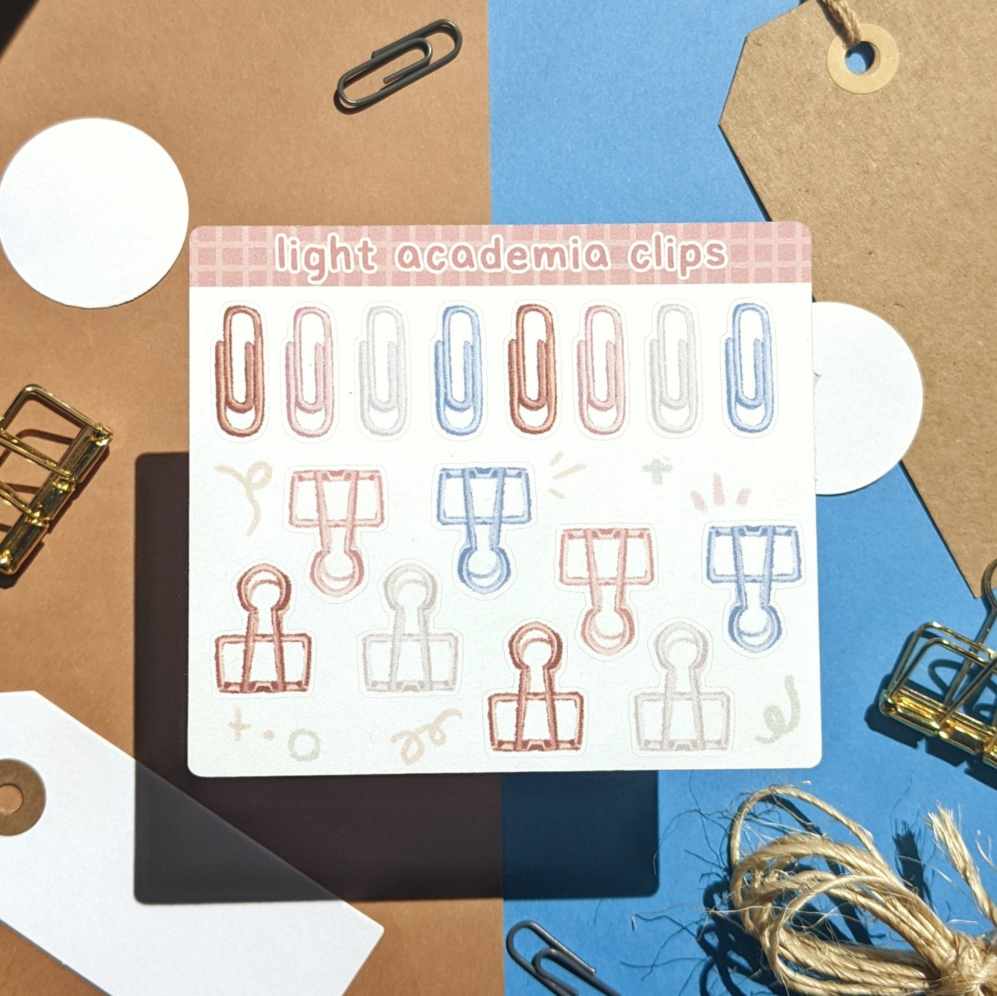 Sticker sheet with illustrations of paper clips and binder clips in bornw, pink, grey, and blue.