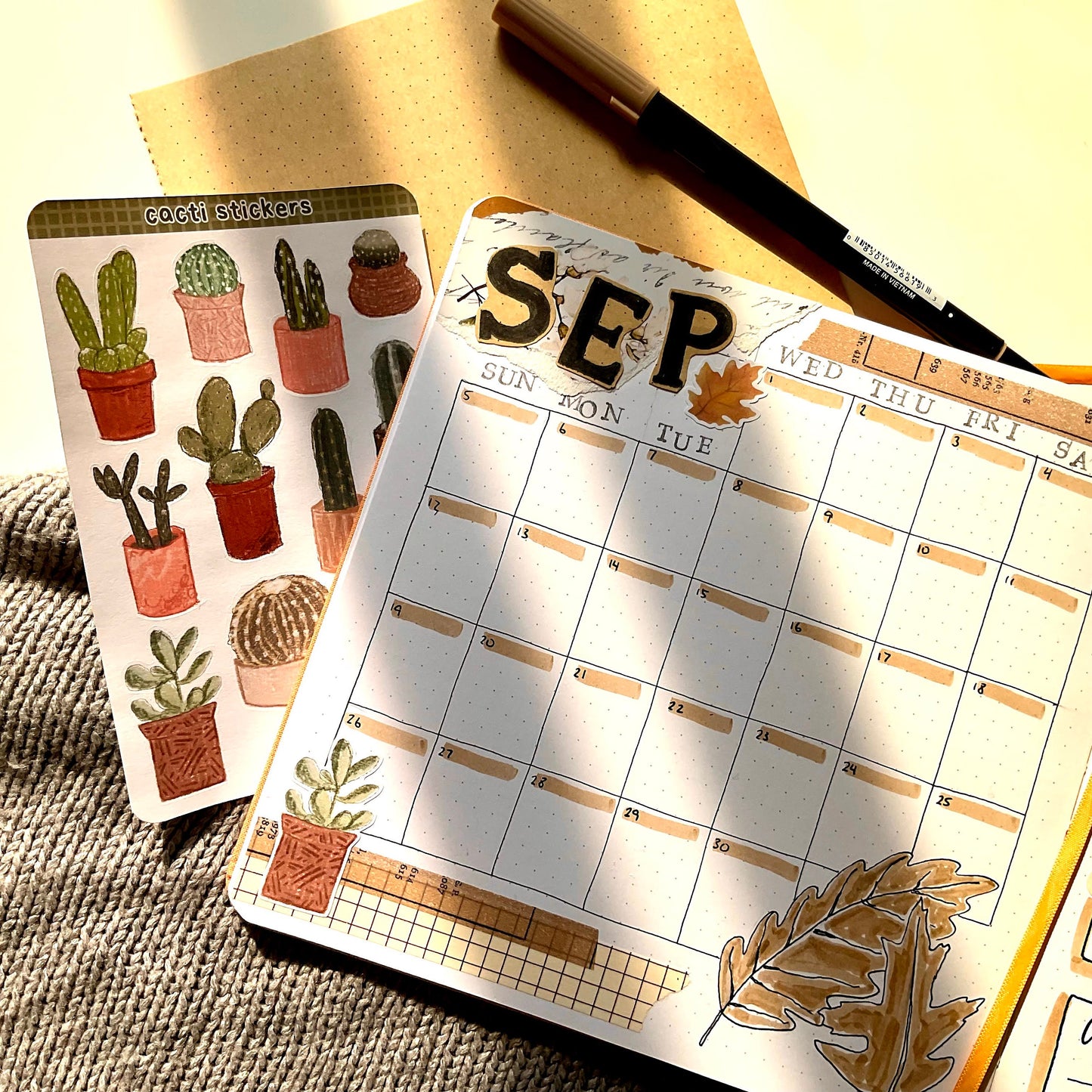 A square notebook page decorated with stickers and markers. It's the monthly calendar for September.