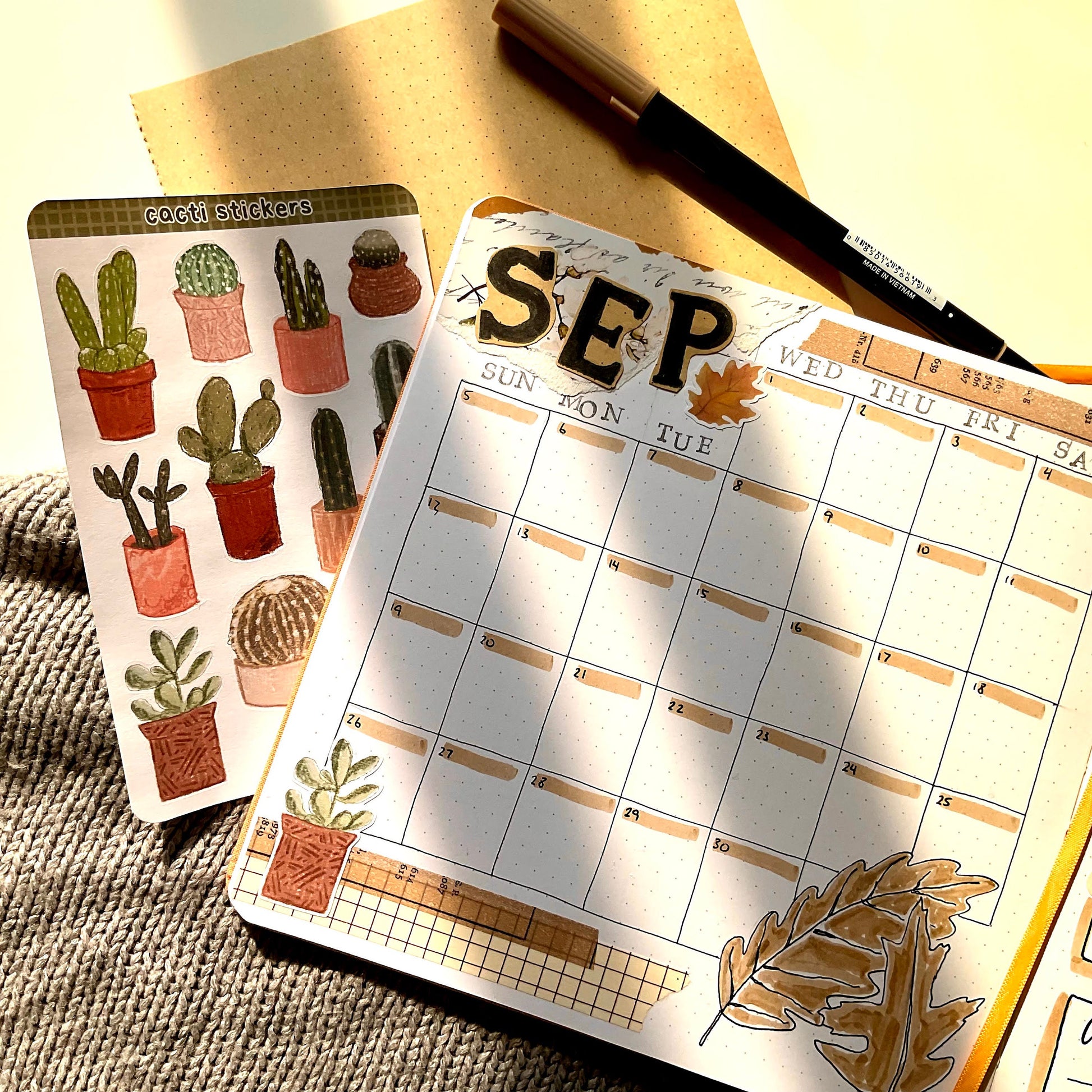 A square notebook page decorated with stickers and markers. It's the monthly calendar for September.